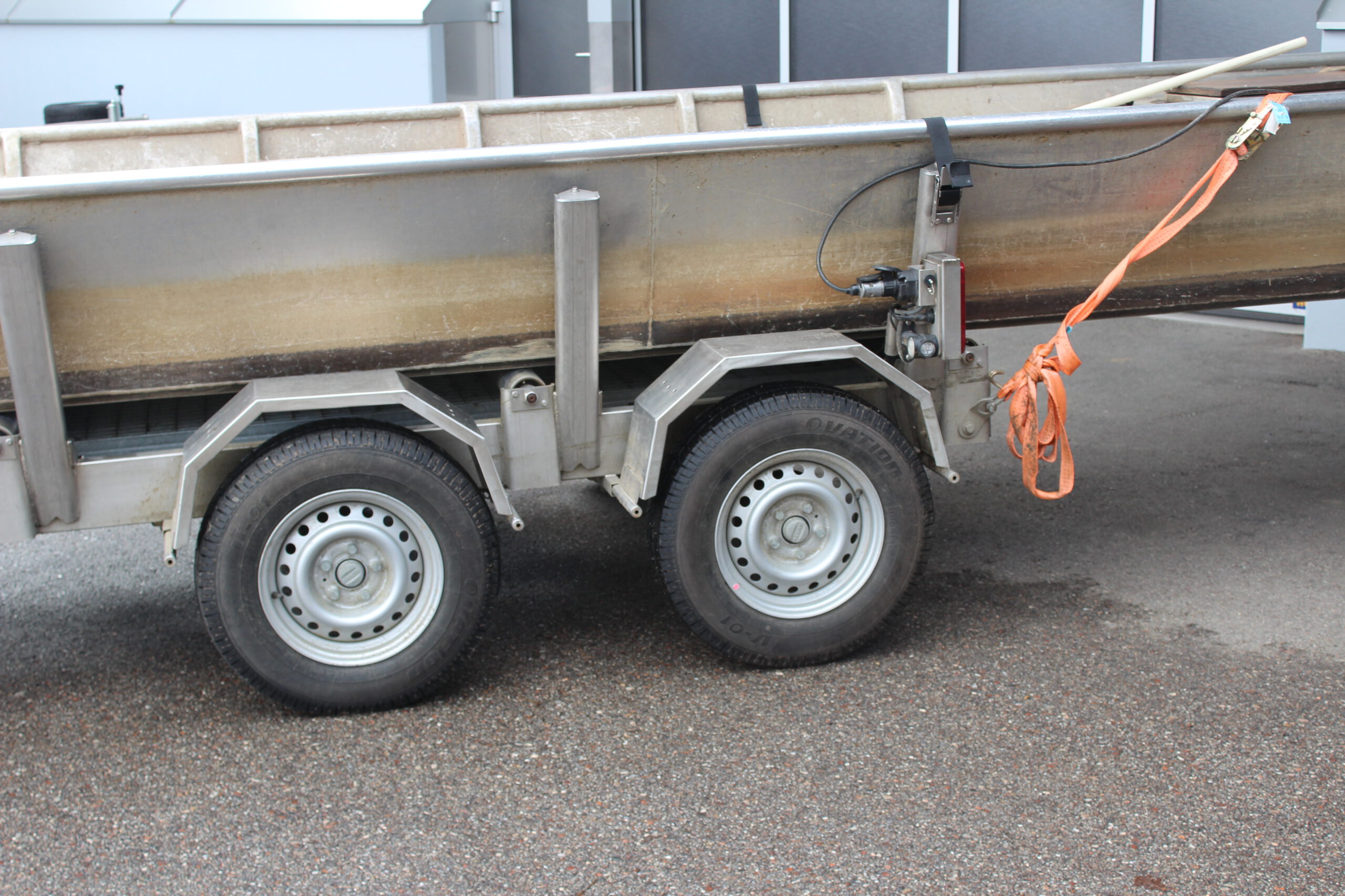 Bootstrailer für Motorzille, Boot auf dem Anhänger vor einer Halle