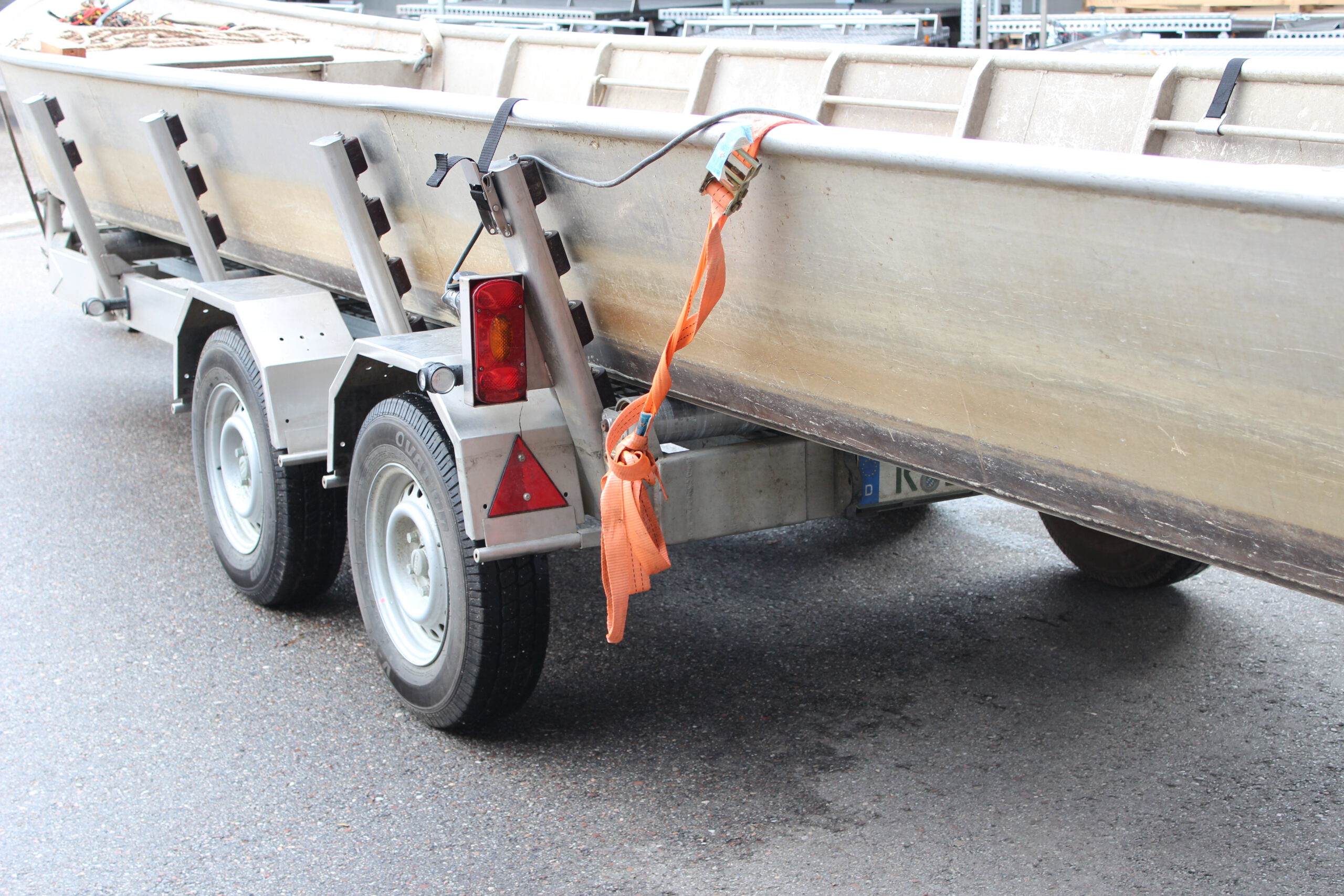 Bootstrailer für Motorzille, Boot auf dem Anhänger vor einer Halle